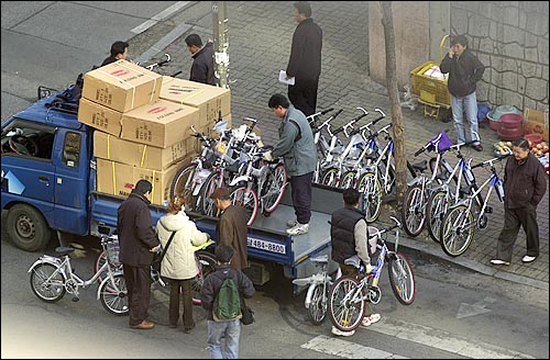 조선일보 판촉사원들이 트럭에 싣고 온 자전거를 내리고 있다. 